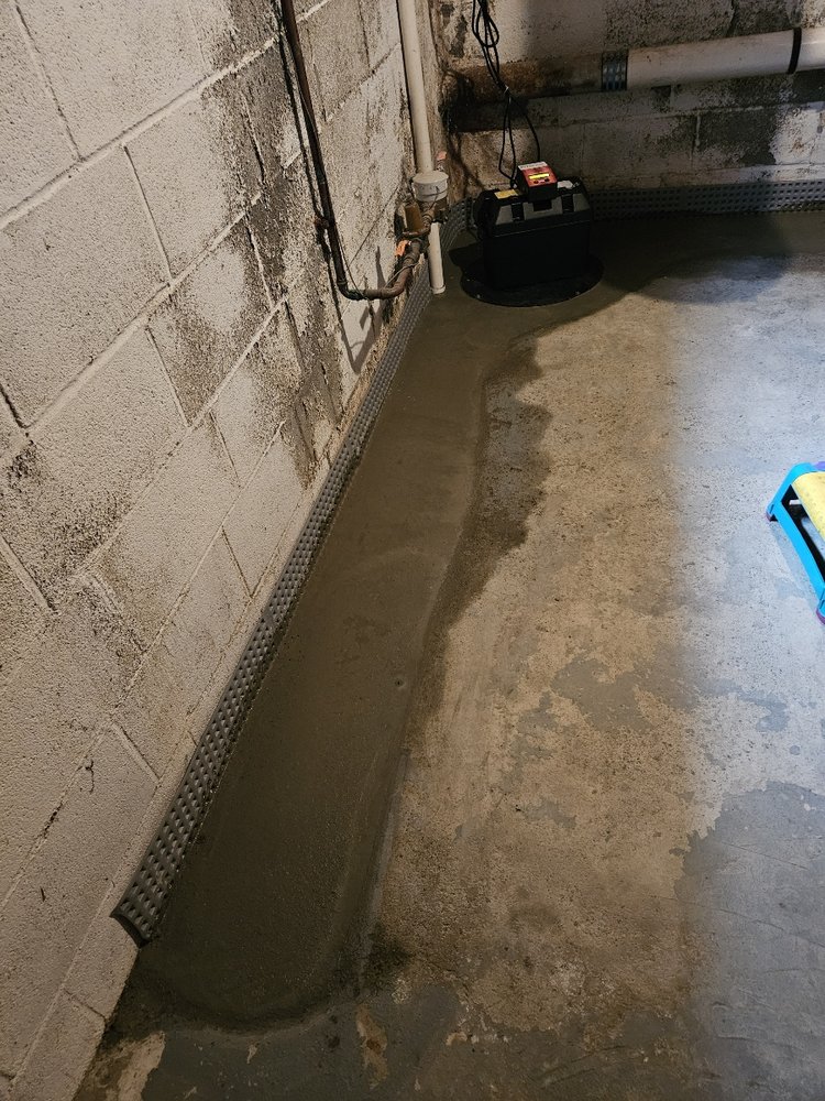 Interior drain tile and sump pump fitted during basement waterproofing in Akron, OH